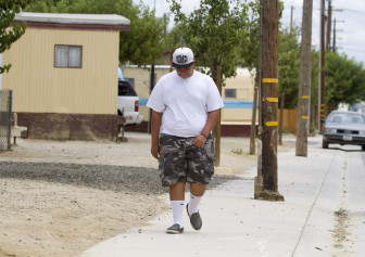 Erick Araujo, 13, walks toward his home in the small California community of Lost Hills. Erick was removed from his school in Lost Hills, California, through next fall semester. But he was sent to an alternative school that’s so far away – 38 miles one way – his farmworker mother reluctantly agreed to put Erick on independent study at home four out five days a week. She is worried because Erick is already talking about dropping out. 