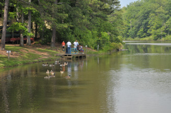 Kids and their teacher-counselors fishing at the lake at Youth Villages.