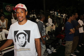A fan sports a “Each One, Teach One” hat, remembering the late Holcombe L. Rucker. Custom Trayvon Martin ‘street ball’ shirts made by the Entertainer’s Basketball Classic and tournament sponsors.