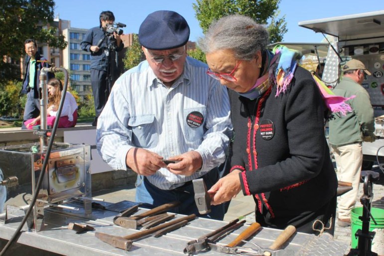 Blacksmith Larry Martin and Marian Wright Edelman, founder and president of the Children's Defense Fund (CDF) examine garden tools made from gun parts. 