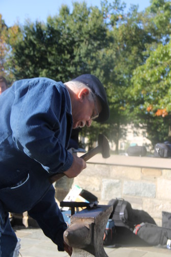 Blacksmith Larry Martin pounds part of a gun into a garden tool outside the Washington National Cathedral Sunday.
