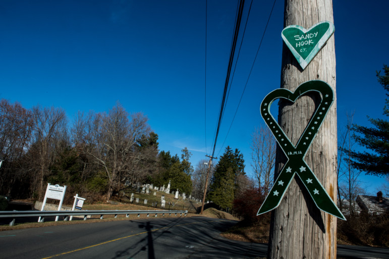 NEWTOWN, Conn., -- Nearly one year after the massacre at Sandy Hook Elementary School, the town has struggled to reclaim its identity as a quaint New England town. A sign hanging on a pole on the road leading to the elementary school.