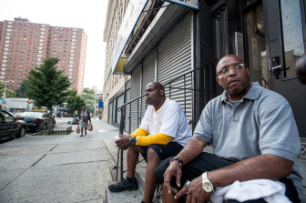 Derrick Haynes (left) and Taylonn Murphy sit on the steps of a building they hope to turn into a community center. 