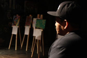 Ralph Perez, 49, watches on as one of his mentees speaks at the All-City Paint Straight Finale art show at Nuyorican Poet's Cafe.