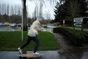 Watson rides a friend’s longboard on Feb. 23 to the Redmond Regional Library where she planned to use the free Internet to search for jobs, which she does most days.