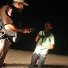 A Hidalgo county constable gives water to a boy crossing the border with two other immigrants as they wait for the U.S. Border Patrol to arrive in August near Granjeno.