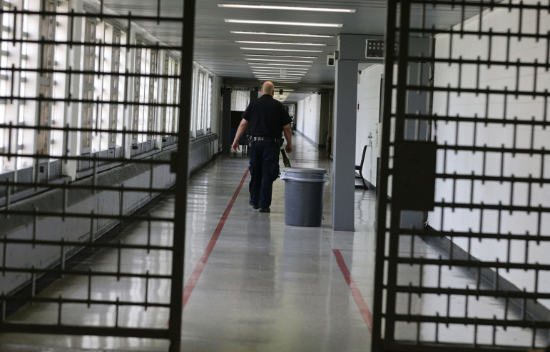 A Rikers Island juvenile detention facility officer walks down a hallway of the jail, Thursday, July 31, 2014, in New York.