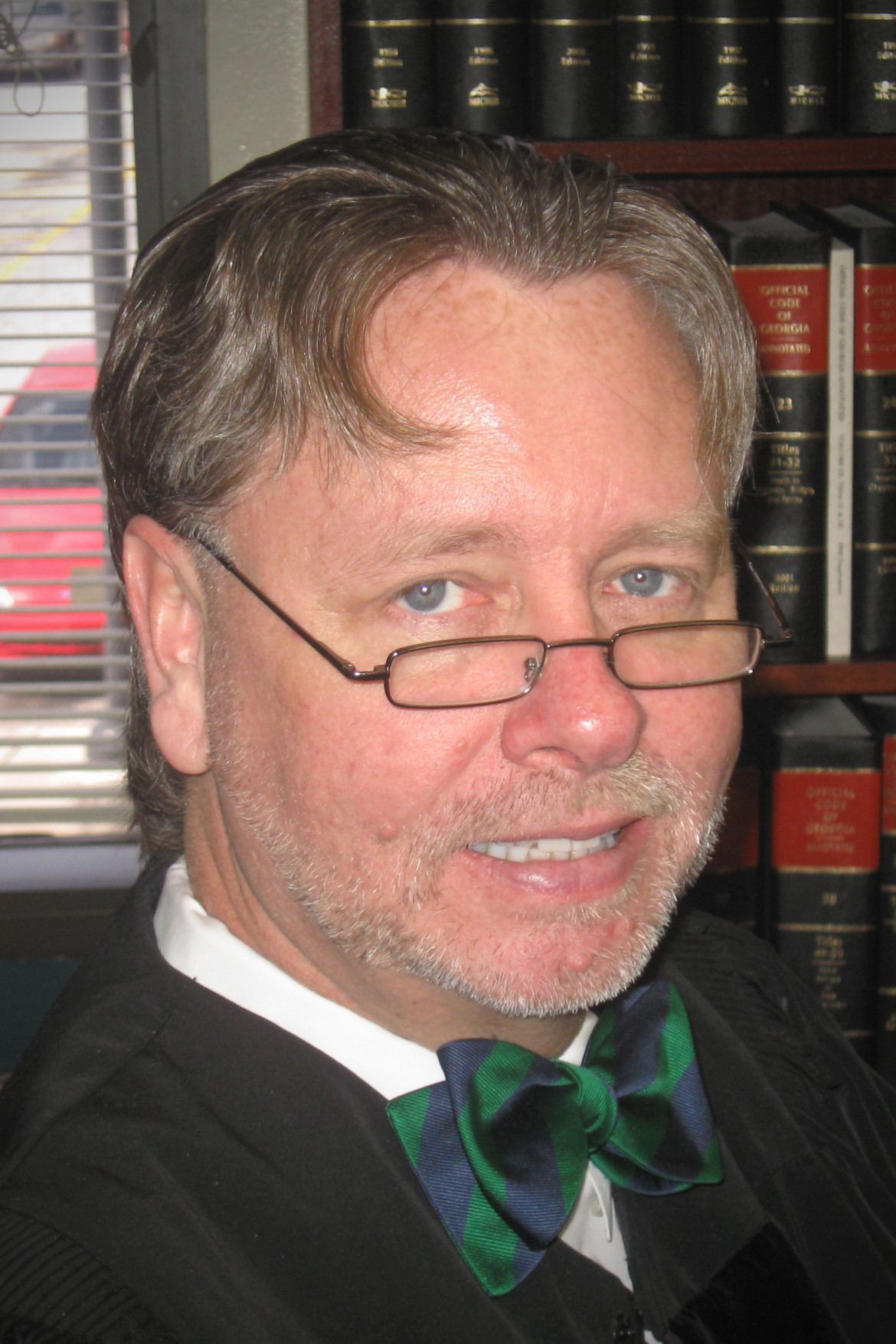 OJJDP: Judge Steven Teske (headshot), man with beard and mustache, black robe, blue and green bowtie