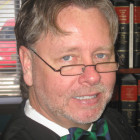 OJJDP: Judge Steven Teske (headshot), man with beard and mustache, black robe, blue and green bowtie