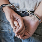 hands in handcuffs against black background