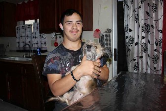 Christian Roldan, 18, holds his dog DD at home in Chino, Calif. He has Down syndrome and can only respond to questions with one or two-word replies. He was hogtied and arrested in 2013 for resisting a school police officer’s attempts to search him at the Chino Valley Unified School District.