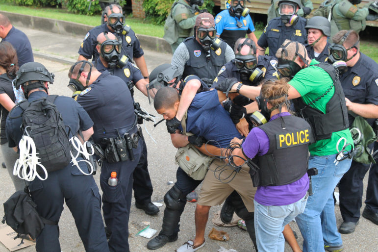 Police wrestle a young man with a camera to the ground during a protest in Baton Rouge on July 10, 2016. Protesters are calling for justice for Alton Sterling, who was killed by Baton Rouge police on July 4, 2016.