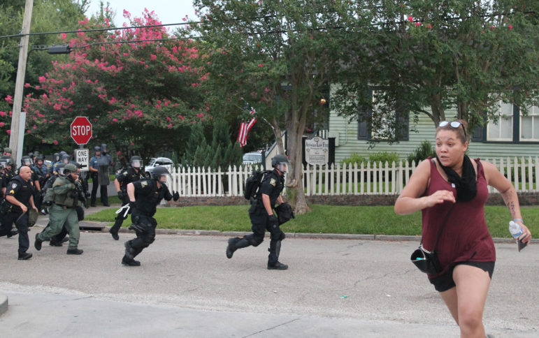 Police chase a protester during a protest in Baton Rouge on July 10, 2016. Protesters are calling for justice for Alton Sterling, who was killed by Baton Rouge police on July 4, 2016.
