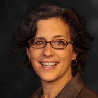 JJDPA: Marcy Mistrett (headshot), CEO of Campaign for Youth Justice, smiling woman in glasses, brown suit.