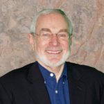 solitary: Mark Soler (headshot), executive director of Center for Children’s Law and Policy, smiling man with glasses, gray beard, mustache; light pink shirt