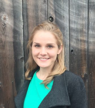 Maureen Washburn (headshot), on policy, communications team at Center on Juvenile and Criminal Justice, smiling blonde woman with green top, gray coat.