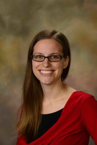Rebecca Fix (headshot), assistant scientist in the Department of Mental Health within the Johns Hopkins Bloomberg School of Public Health, smiling woman with long, light brown hair, glasses, red top over black.