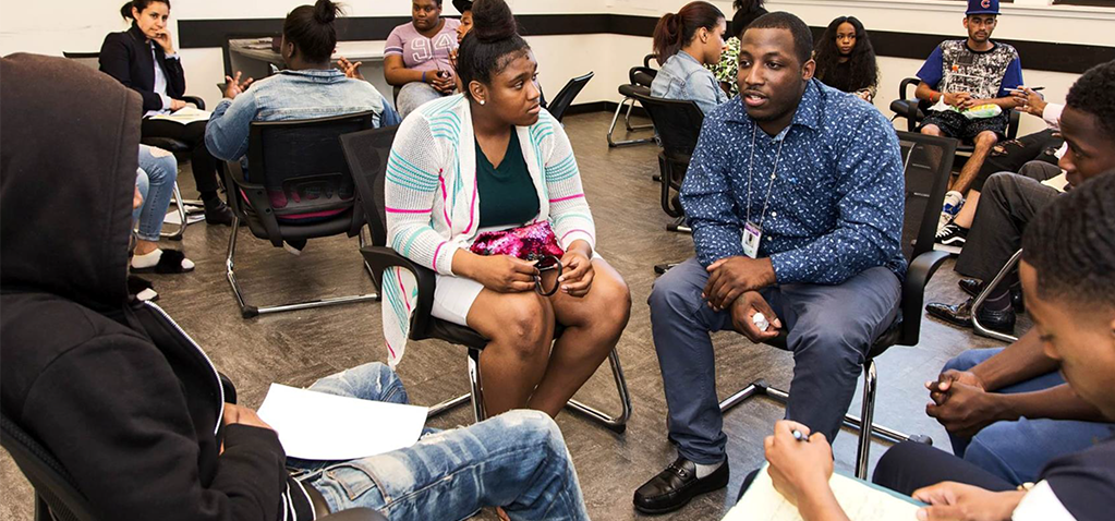 Mentoring program works: Young people sit in circles and talk.