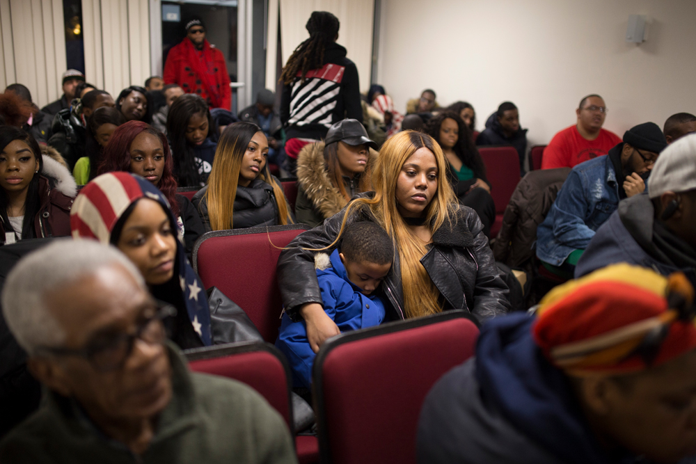 Remembering Kimani Gray, crowd of sad-looking mostly young adults sit in rows of chairs.