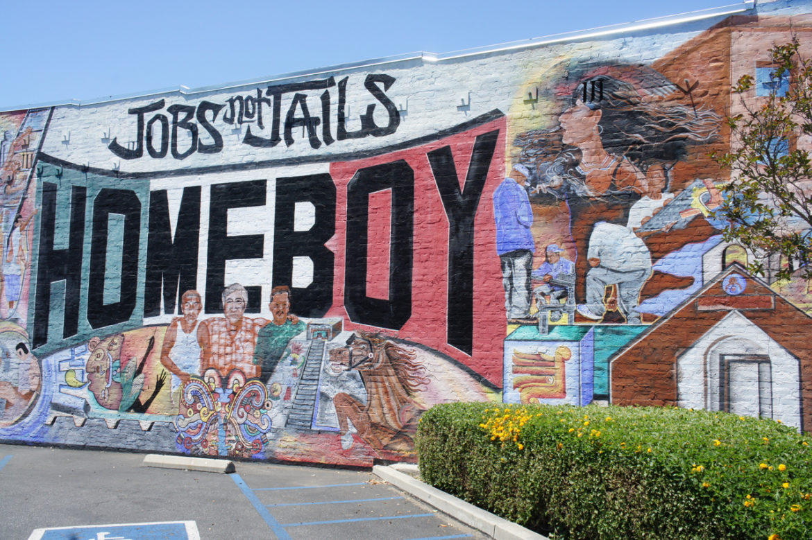Gangs: Colorful mural on brick wall outside says Jobs not Jails Homeboy