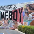 Gangs: Colorful mural on brick wall outside says Jobs not Jails Homeboy