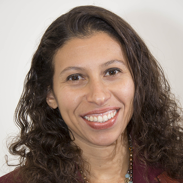 Massachusetts: Sana Fadel (headshot), acting executive director of Citizens for Juvenile Justice, smiling woman with long brown curly hair, necklace, maroon jacket, white shirt.