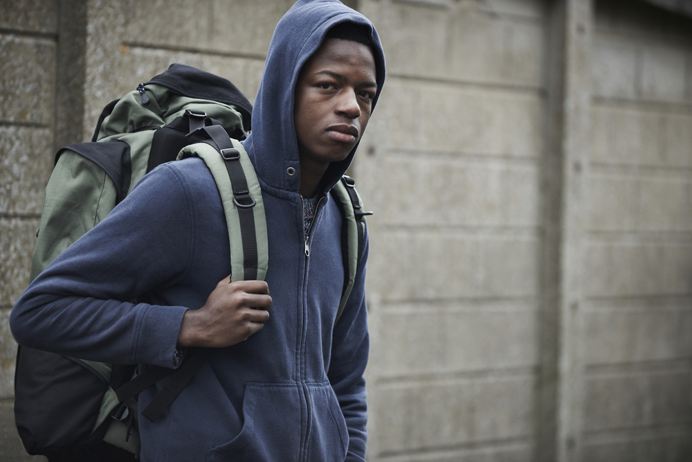 Racial bias: Homeless Teenage Boy On Streets With backpack