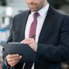 independent monitor: Middle-aged businessman writing on clipboard