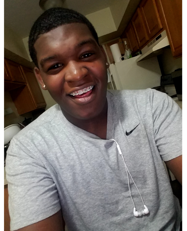 LGBTQ: Ja'Vaune Jackson (headshot), member of Annie E Casey Foundation Youth Advisory Council and Illinois Juvenile Justice Commission, smiling teen with transparent braces, in gray T-shirt, wearing earring and earbuds