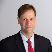 fees and fines: Brent Pattison (headshot), director of Middleton Center for Children’s Rights, man with thinning hair, dark suit, light blue shirt, red tie