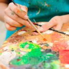 recreational therapy: young girl paints a picture using palette