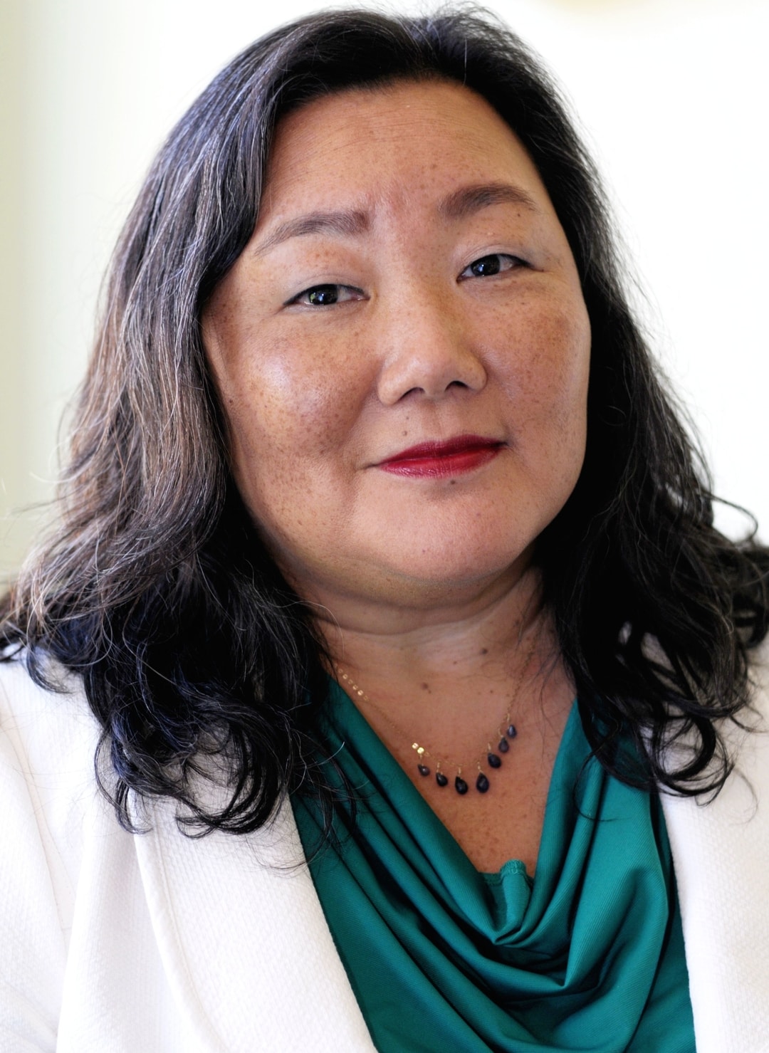National Girls Initiative: Jeannette Pai-Espinosa (headshot), president of National Crittenton, woman with long dark hair, necklace, white jacket, green top