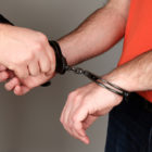 violent offenders: A police officer releasing a detainee's handcuffs. Headshots: