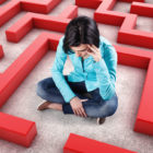 TAG: Sad girl sits in a labyrinth with red walls