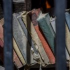 education: Old used books behind the metal bars. Education in jail.