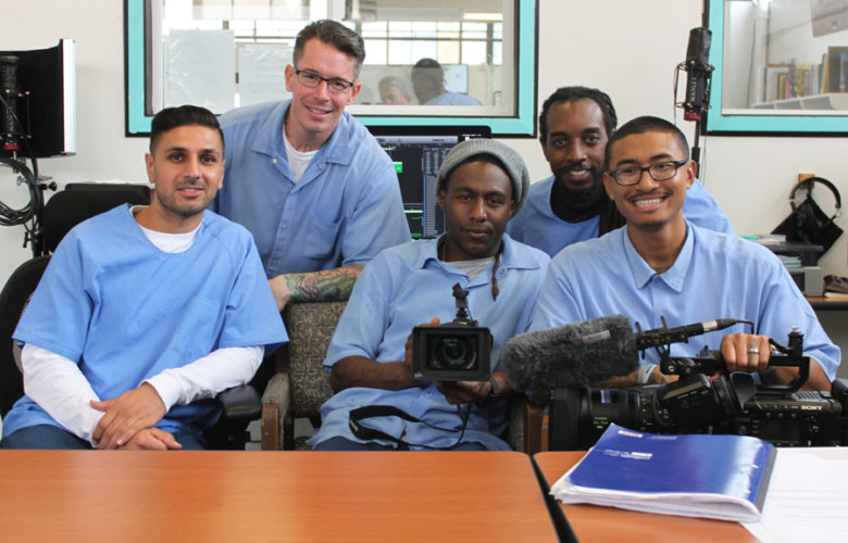 San Quentin: 5 men in light blue sitting or leaning, holding camera equipment.