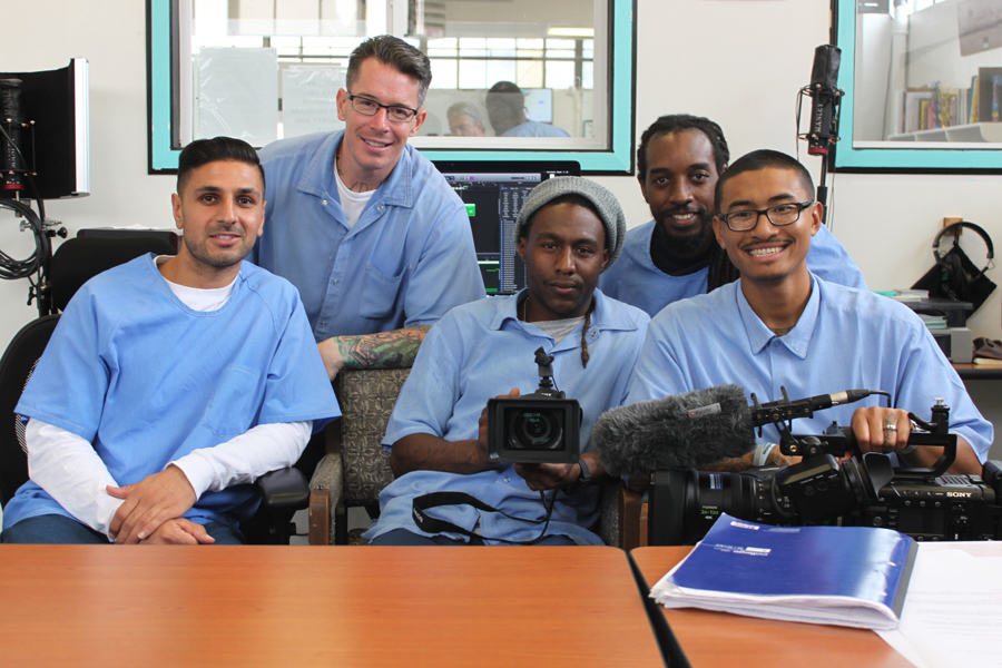 San Quentin: 5 men in light blue sitting or leaning, holding camera equipment.