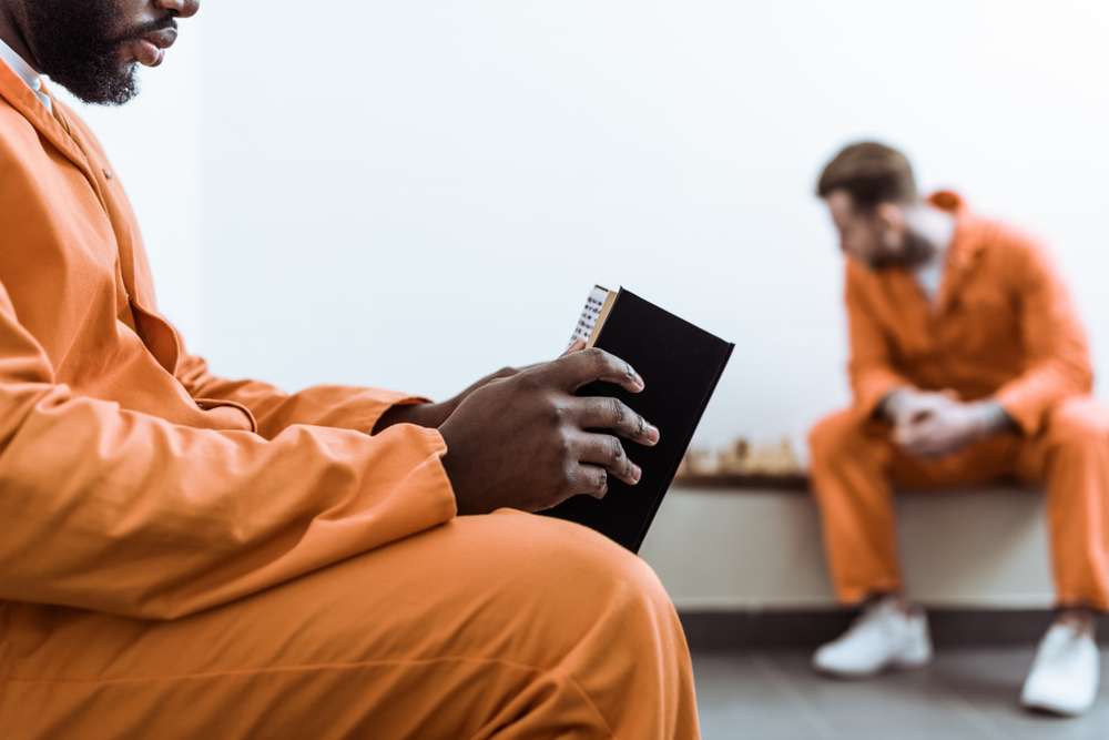 cropped image of african american prisoner reading book