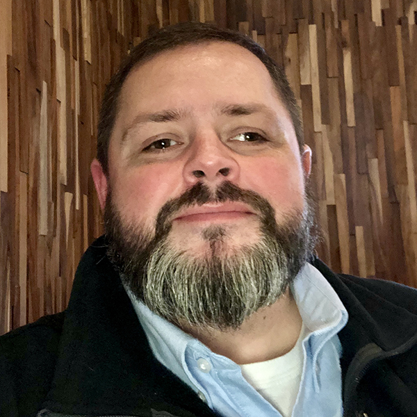 Colin Slay (headshot), director of juvenile court operations for Clayton County, Ga., bearded man in zip-up dark jacket, light blue shirt, white undershirt.