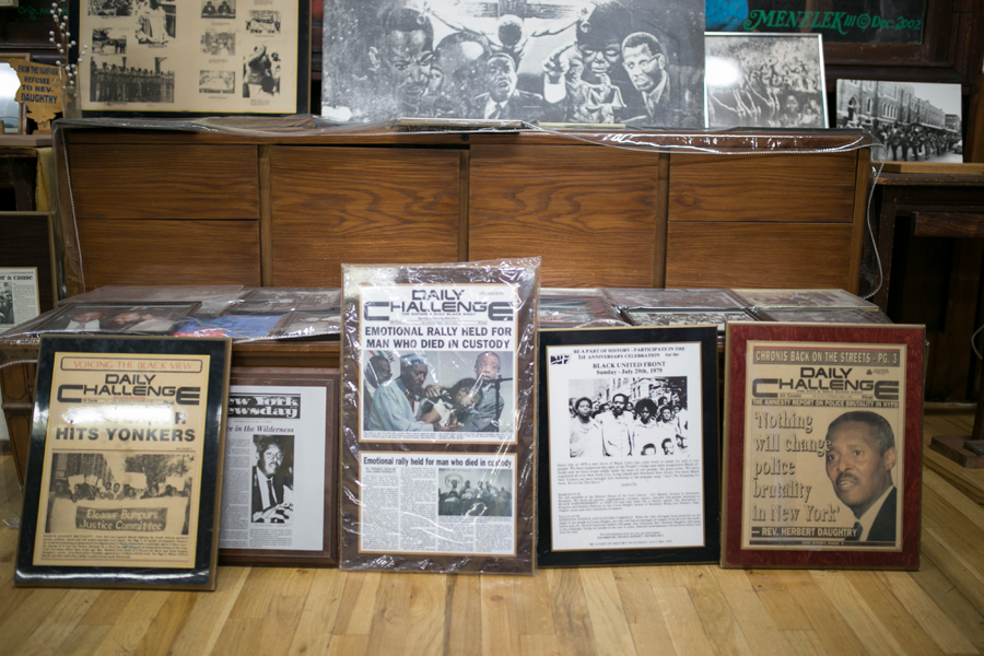 police shootings: Framed newspaper front pages, sitting on floor.