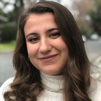  storytelling: Aisha Chabane (headshot), communications and policy intern at Center on Juvenile and Criminal Justice, smiling woman with long brown hair, white turtleneck.