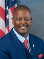 Florida legislature: Smiling man in blue suit, light blue shirt, red polka-dotted tie.