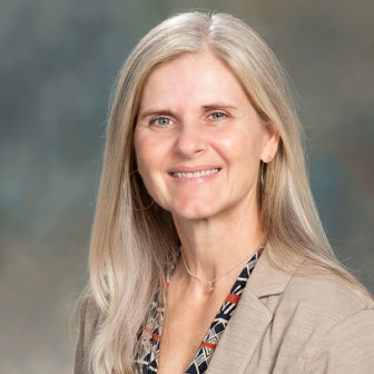 dual system youth: Denise C. Herz (headshot), professor at Cal State LA, smiling woman with long blonde hair in beige jacket, patterned blouse.