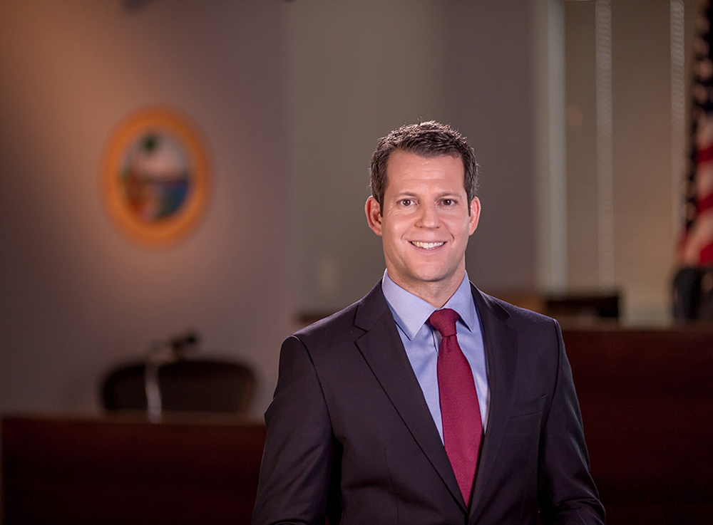 Florida: Smiling man with short brown hair, dark suit, light blue shirt, red tie.