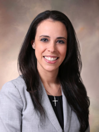 death penalty: (headshot), Ingrid Delgado, a lobbyist for Florida Conference of Catholic Bishops, smiling woman with long black hair, gray jacket, black top, cross on necklace.