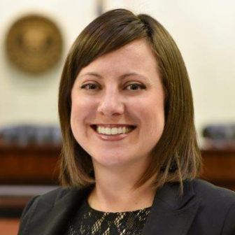 trauma-informed: Brenidy Rice (headshot), deputy director of court services with State Court Administrator’s Office, smiling woman with brown hair, black blazer, black lace top