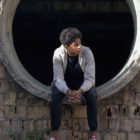 reentry: Depressed black teenager sitting in end of empty culvert