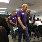 Florida criminal justice: 2 men in purple T-shirts in crowd of people with folding chairs set out