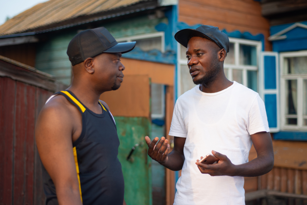 success stories: Two black guys discuss issues with background of a house