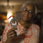 police shooting: Woman holds up ornament with photo of man’s face.